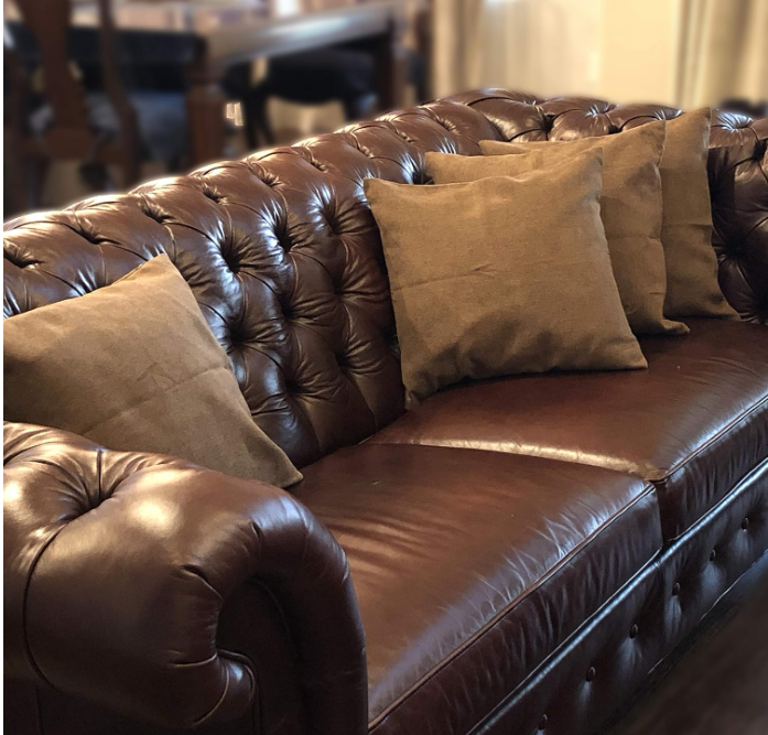 Decorative throw pillow covers on brown leather sofa living room decor